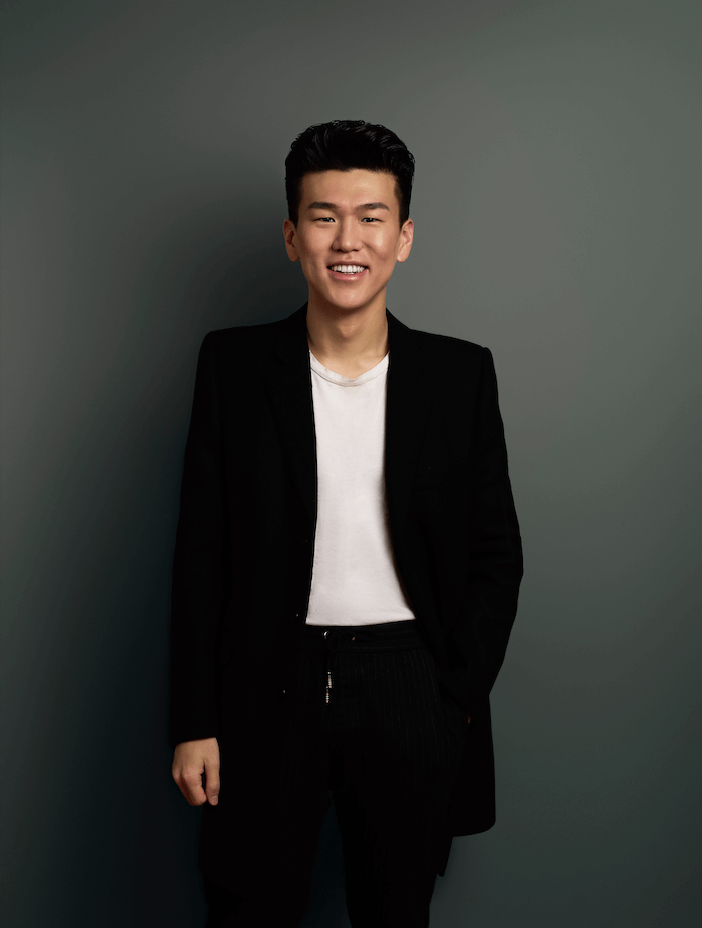 Casual sharp man on a gray backdrop smiling into the camera