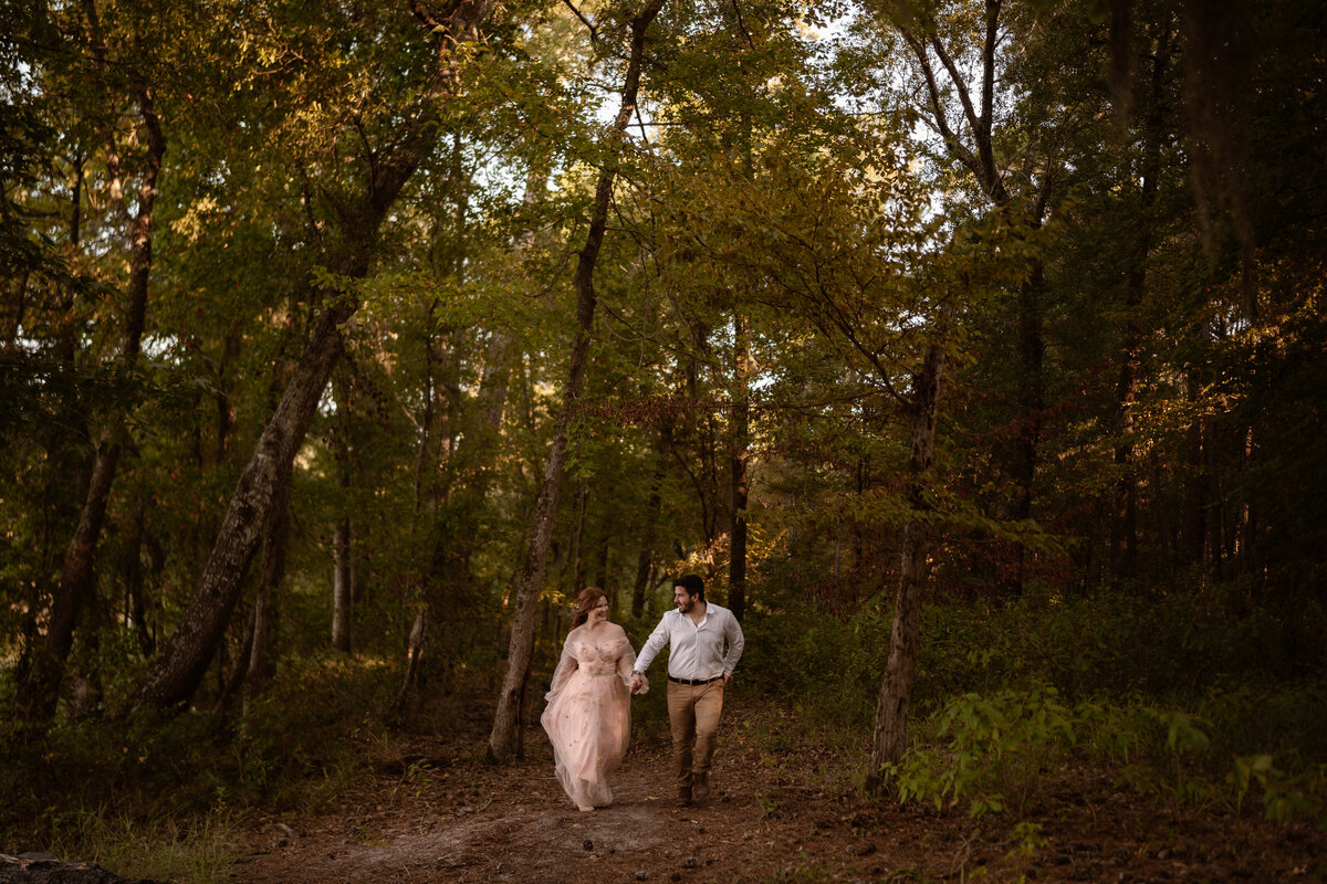 Couples runs through the forest after their intimate Texas elopement
