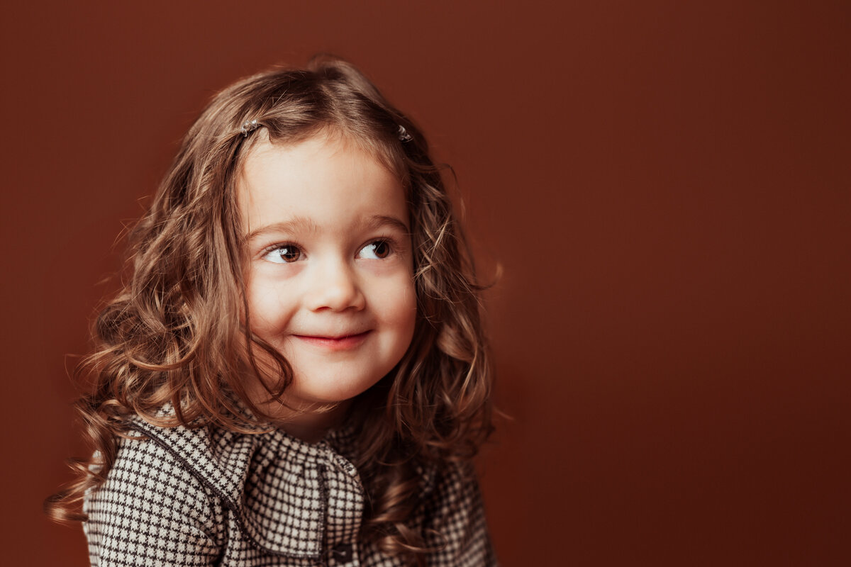 girl-smiling-face-brown-studio-backdrop