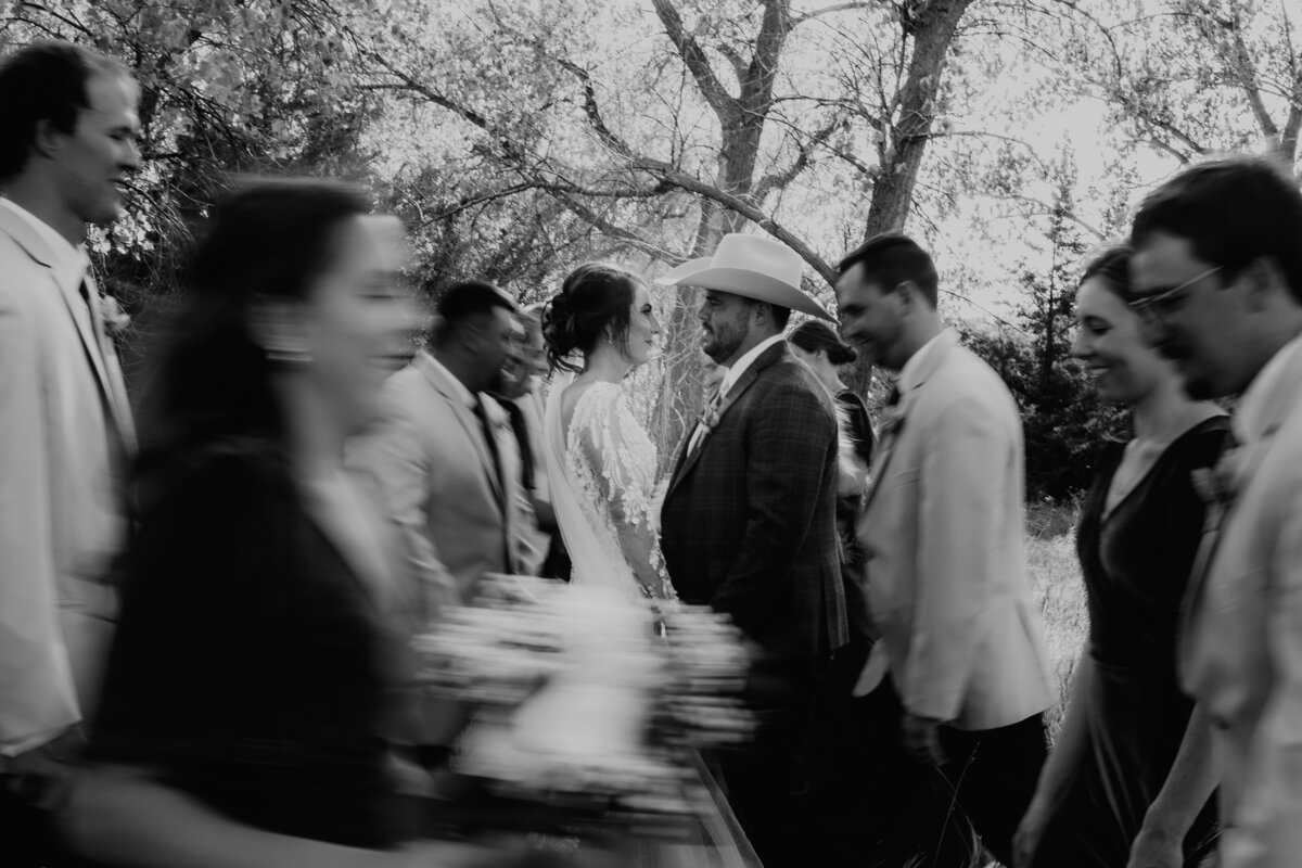 TRENDY BLUR OF BRIDE AND GROOM WITH WEDDING PARTY ZOOMING PAST