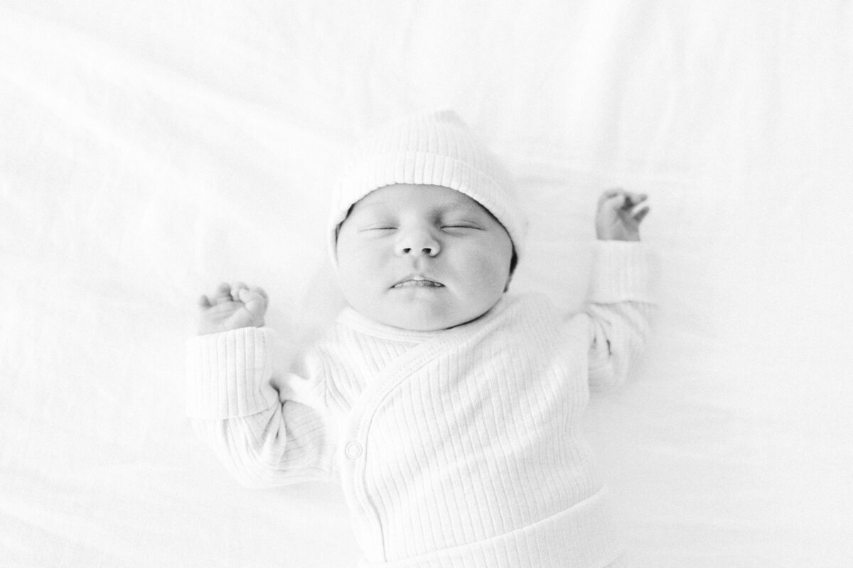 sleeping-newborn-in-white-wrap-and-hat-bend-portrait