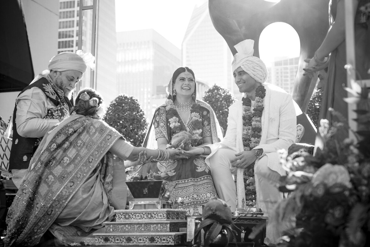 Indian wedding ceremony at the Grand Bohemian Hotel Charlotte captured by DeLong Photography. The bride and groom smile during the Kanyadaan ritual, surrounded by family and traditional décor. Charlotte Indian wedding photographer specializing in cultural wedding traditions.