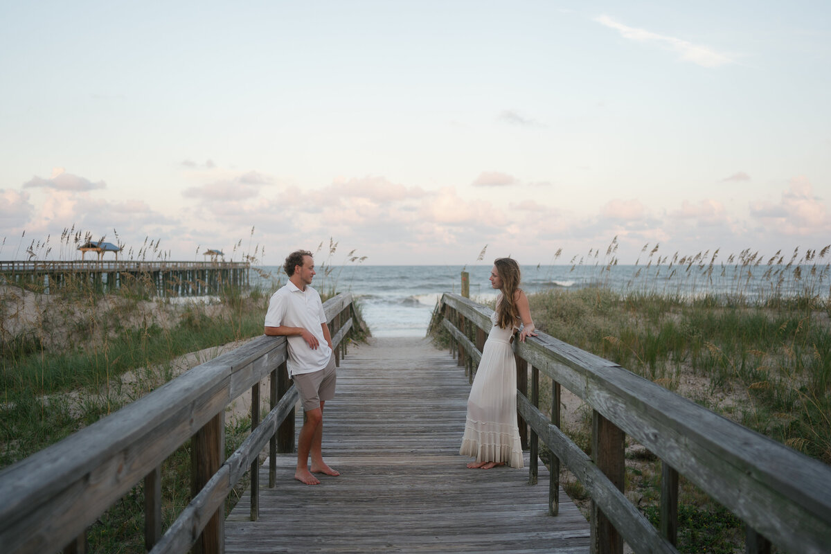 couple talking to each other on boardwalk for engagement photography in florida
