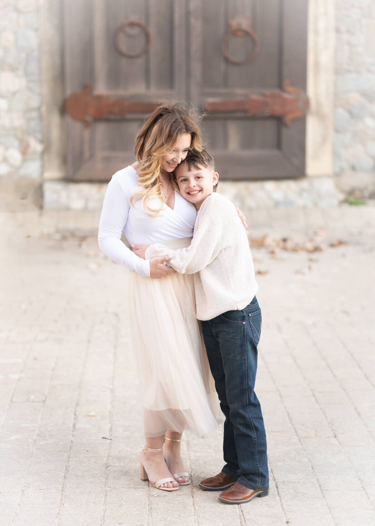 mother and son embracing wearing neutral colored clothes, light and airy feel