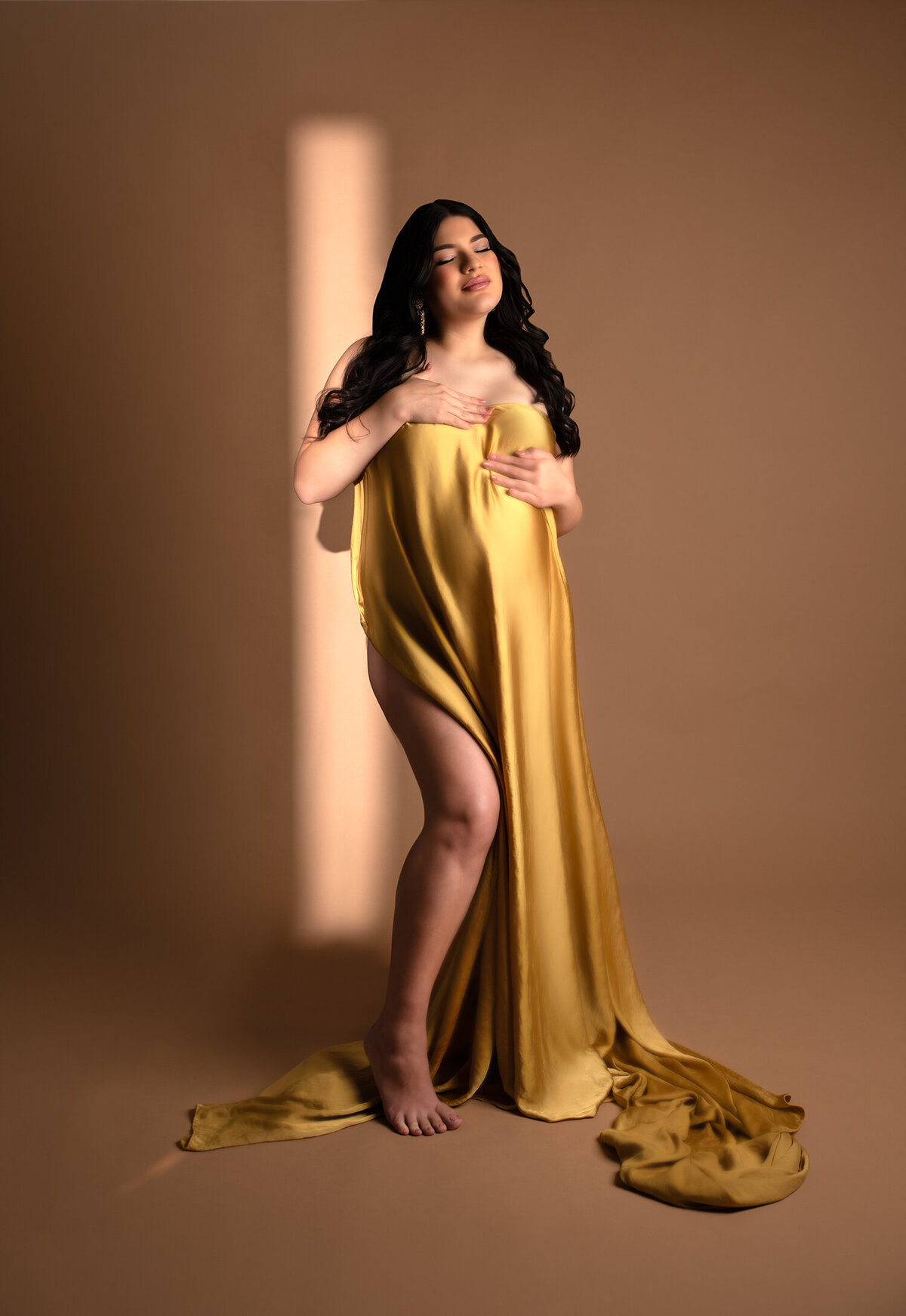 pregnant mom drapped in gold fabric