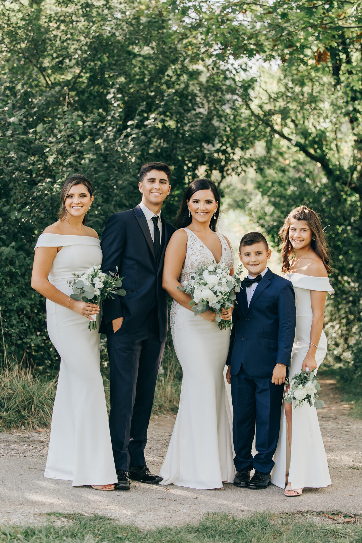 Bride and groom posing with their junior wedding party