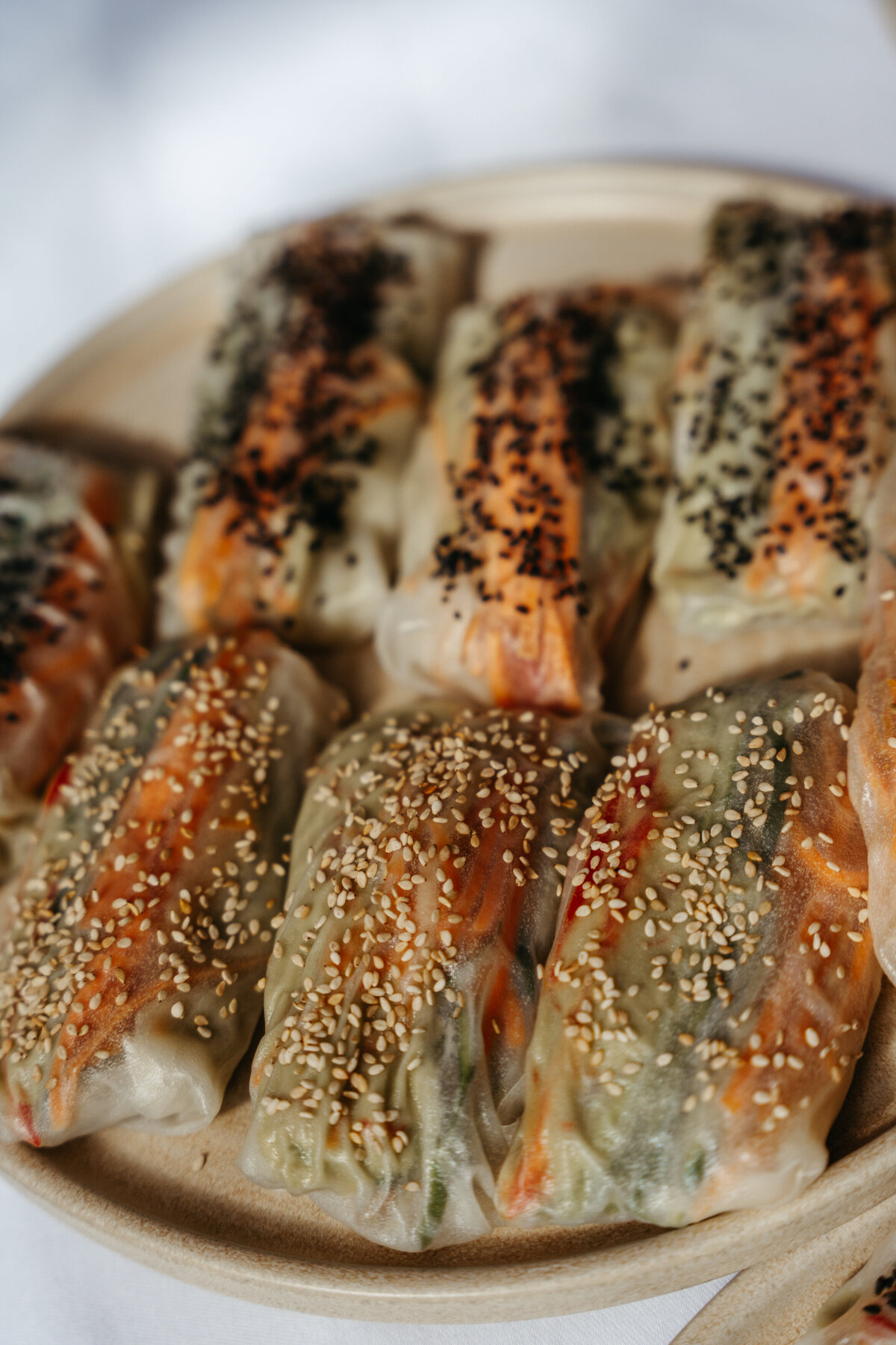 Plate of vegan spring rolls with sesame seeds