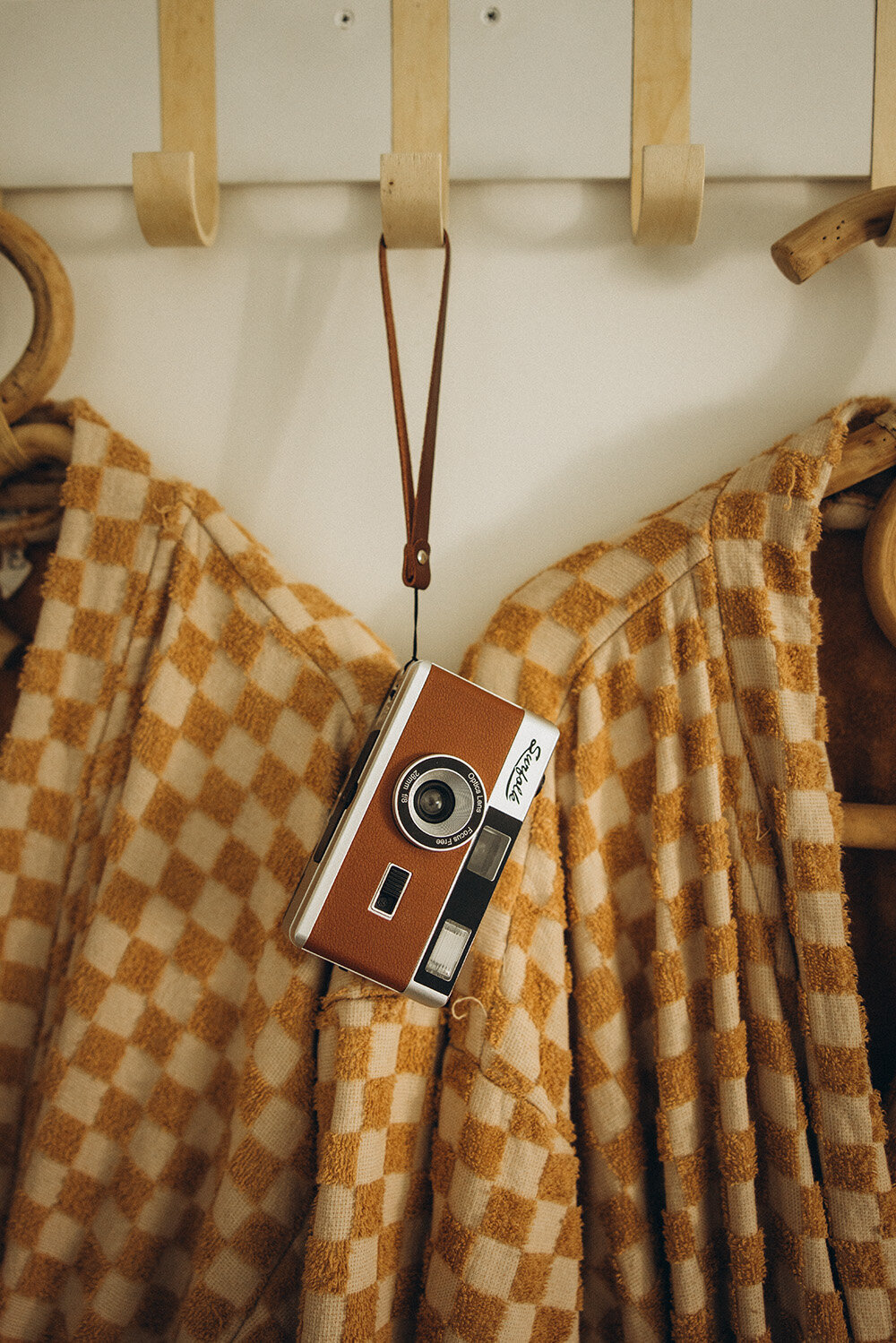 product photography on the sunshine coast of retro film camera, hanging on a coat rack