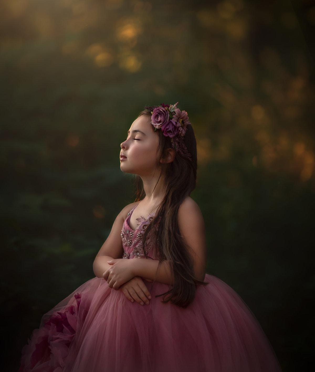 A young girl in a calm pink gown standing in an outdoor setting. Photo taken by Sonia Gourlie.