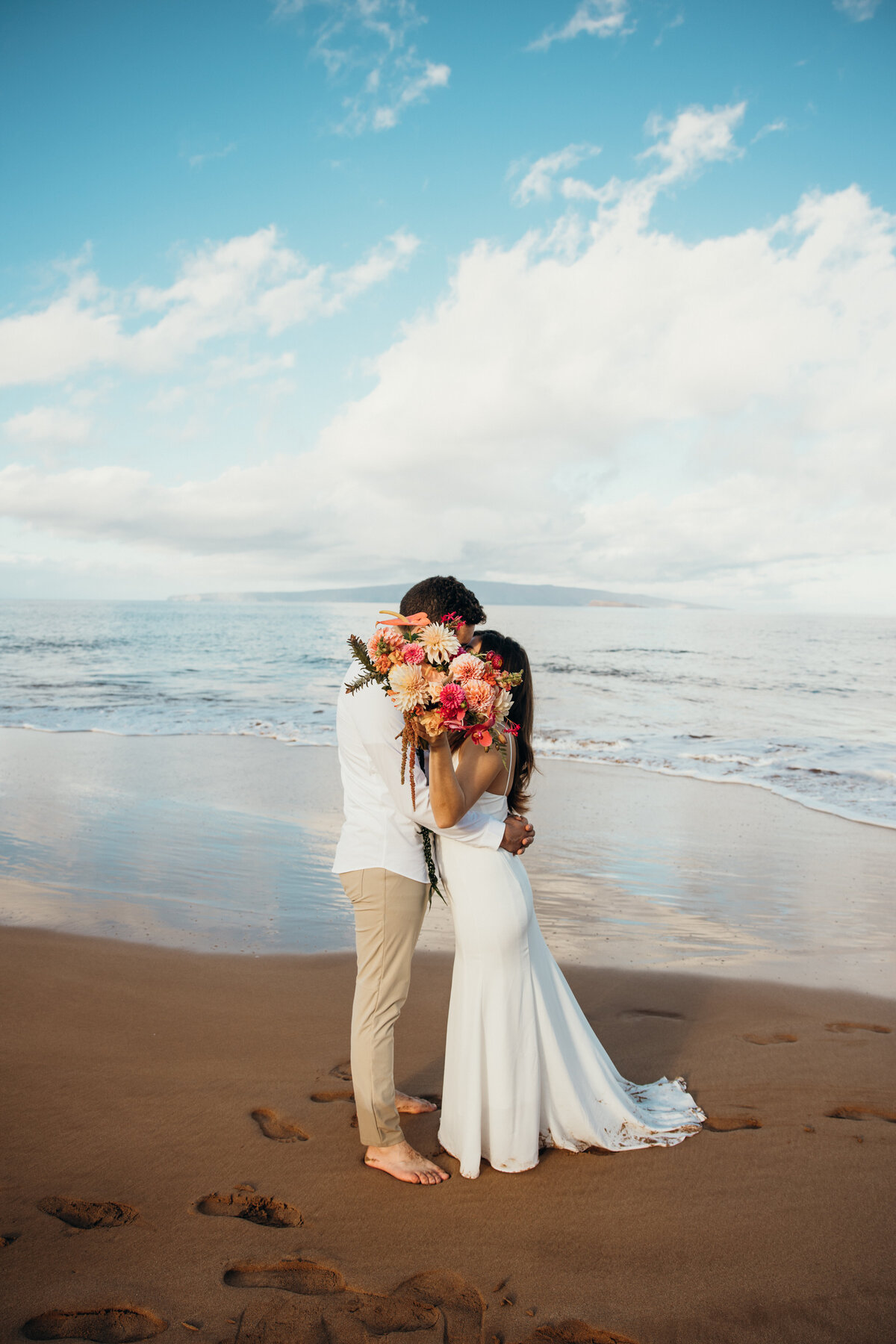 Maui Wedding Photographer captures bride and groom kissing behind bouquet