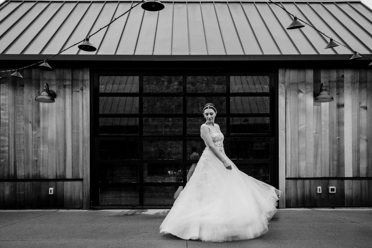 Classic black and white bridal portrait with flowing wedding gown at rustic Estate Yountville barn venue by professional Bay Area wedding photographer