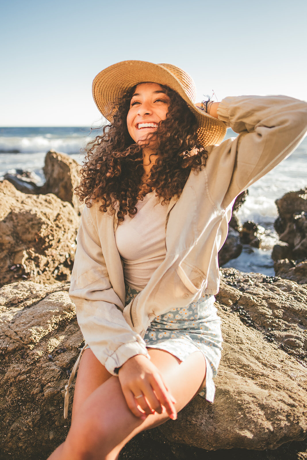 Olivia holds on to her hat as the wind blows at El Matador beach.