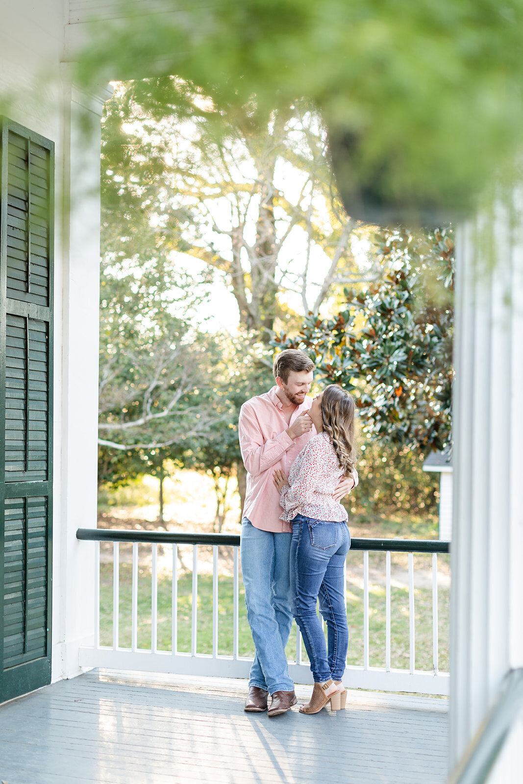 Engagement photo of couple on porch at Springhill College; Mobile, AL