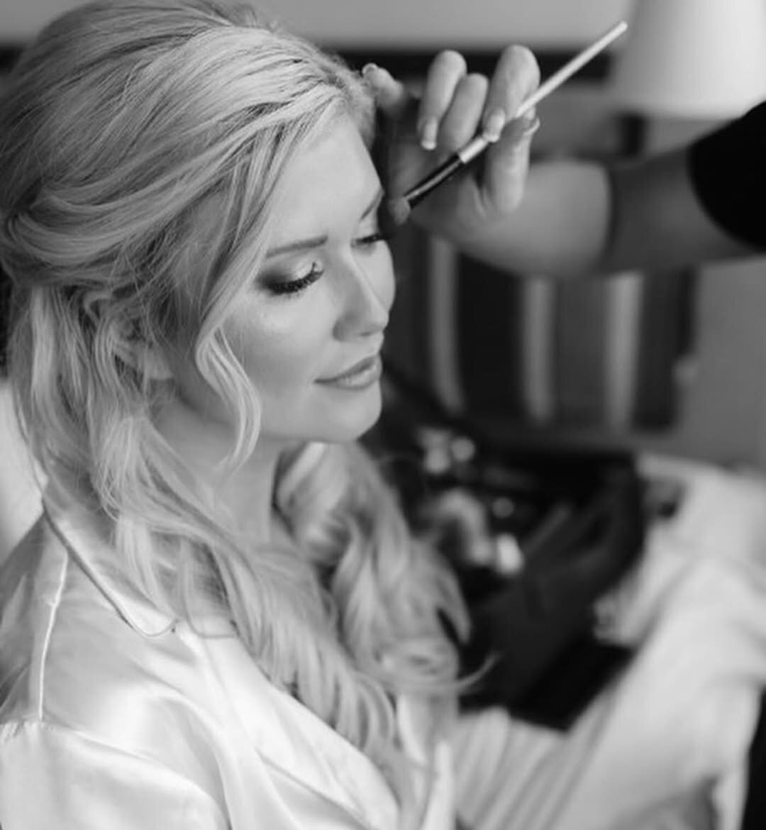 Big Sky, MT on-site hair and makeup artist brushes eye shadow onto a bride for her wedding hair and makeup 