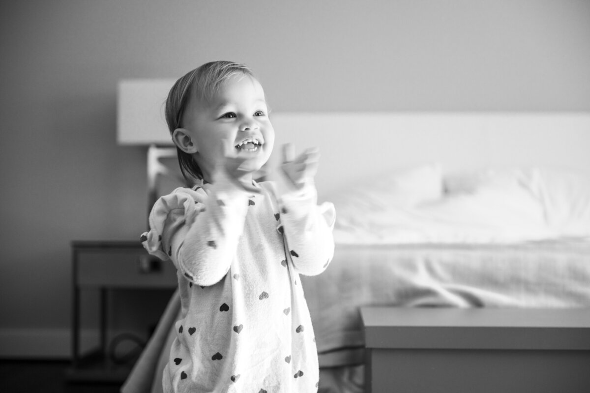 Toddler clapping hands in bedroom black and white