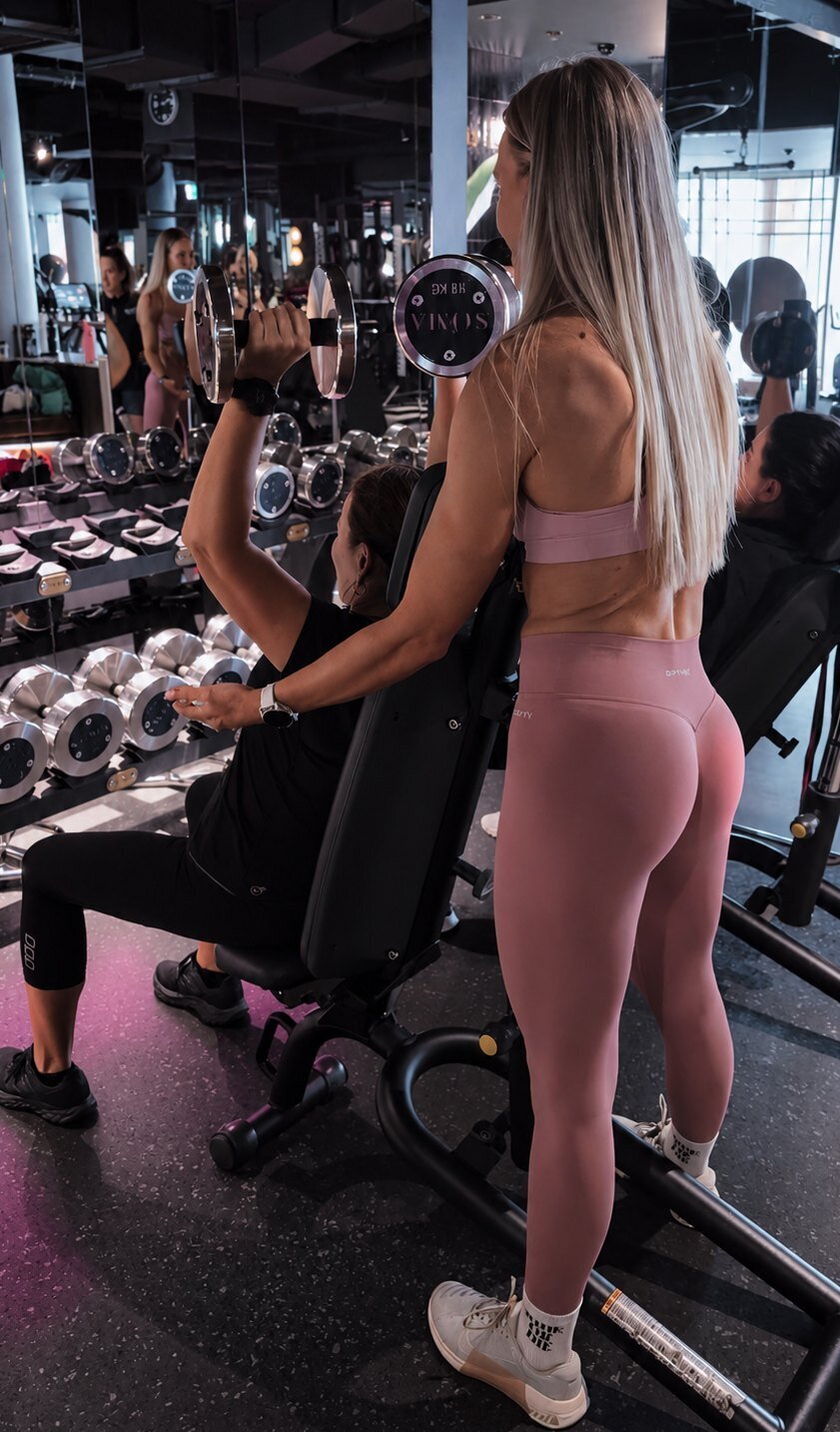 Libby coaching a client through a dumbbell press