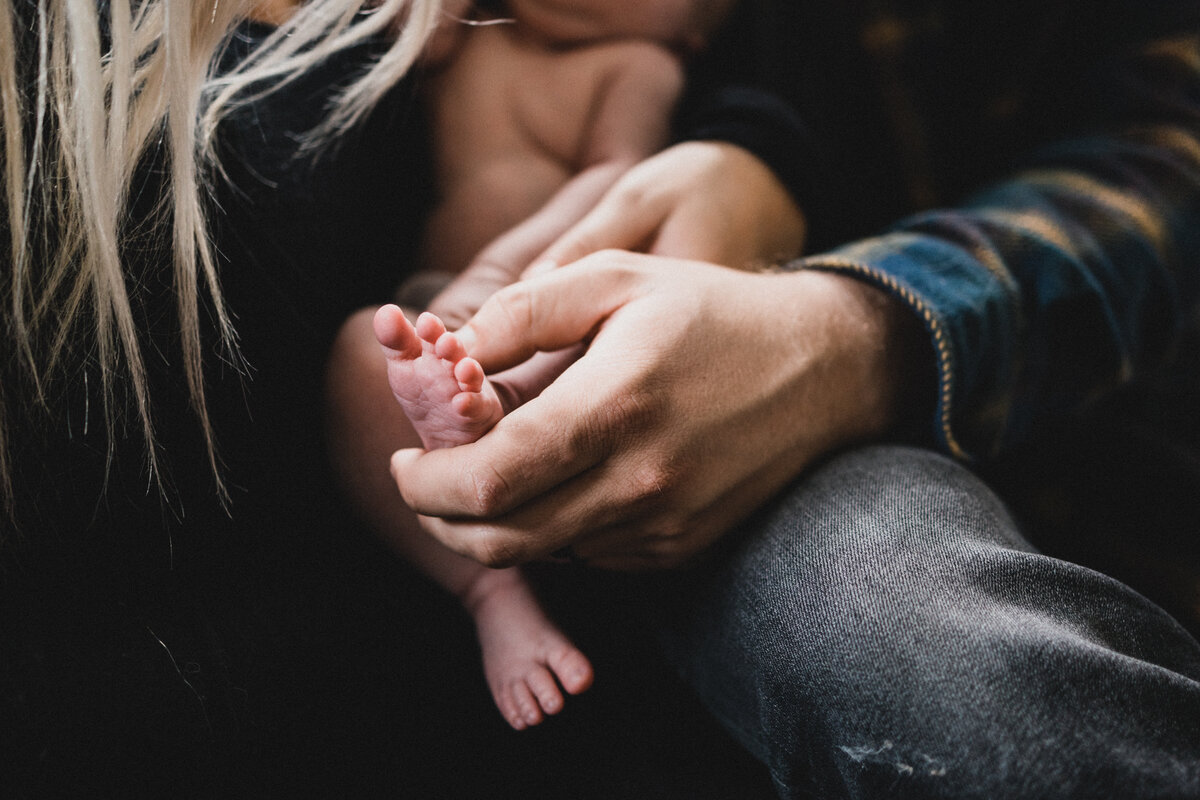 Dad holding newborn son's toes