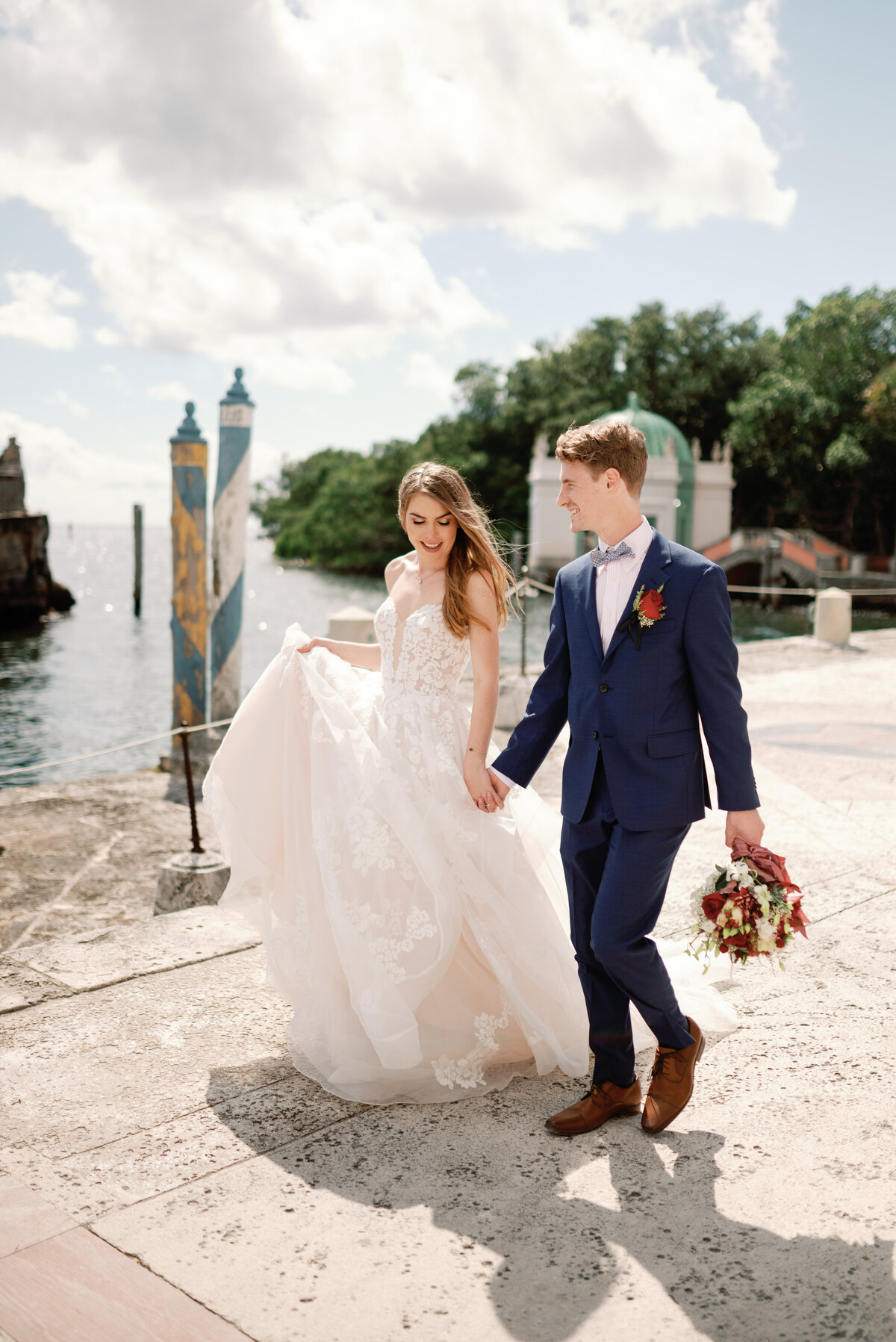 Bride and groom walking along the bank of a waterway in South Florida