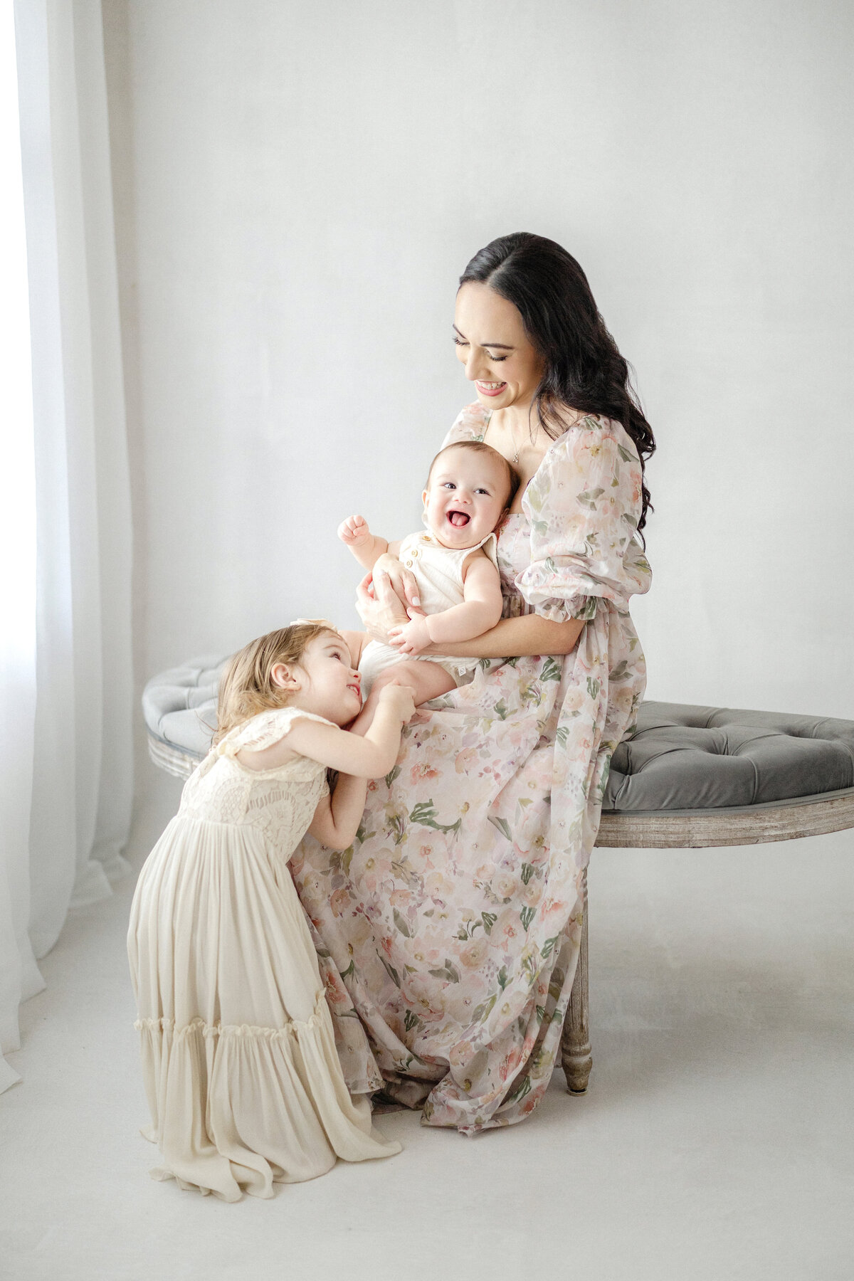 Tampa 6-month milestone portrait of smiling baby boy, big sister and mother in natural light studio