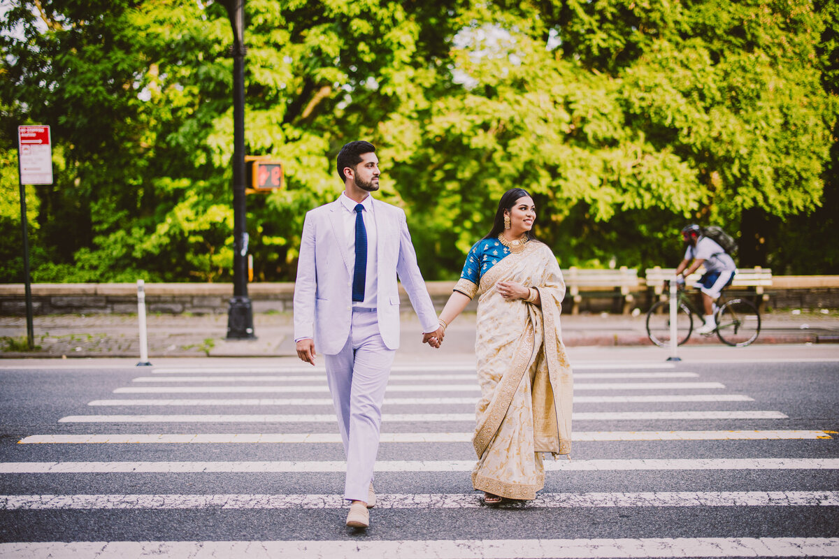 A couple walking through the crosswalk in nyc