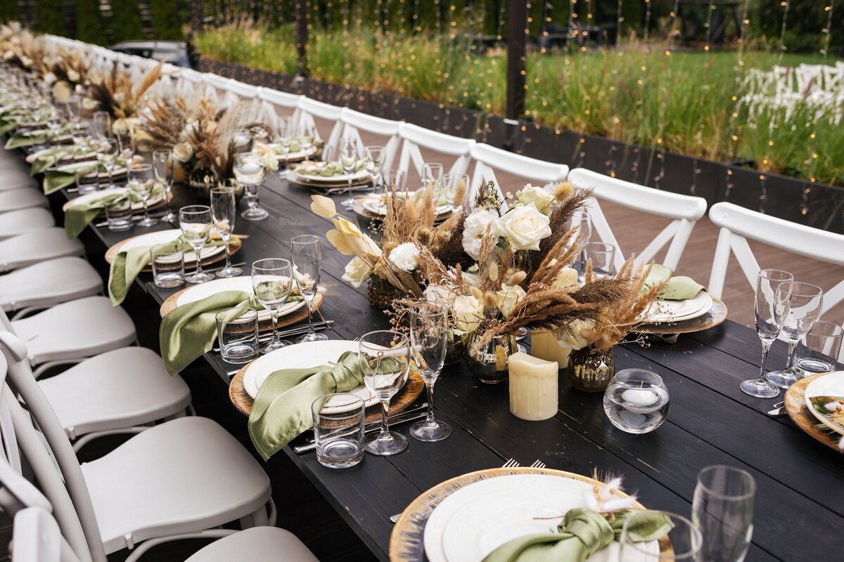 Wedding tablescape with black tablecloth and gold and green accents