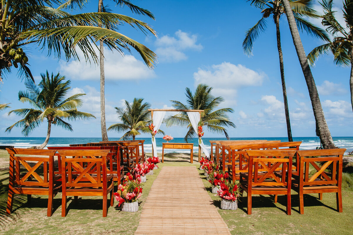Beach wedding ceremony site with wooden chairs for guests
