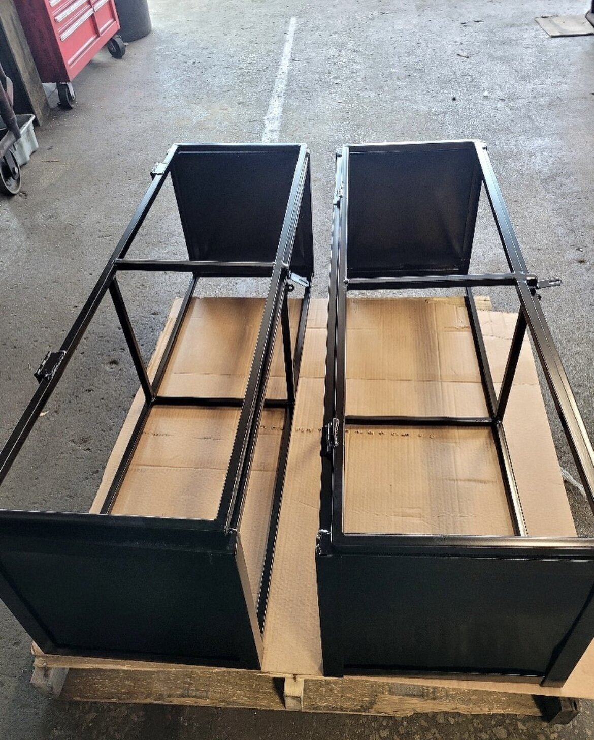 Custom-fabricated welded steel bins designed for commercial trash enclosure use before installation.