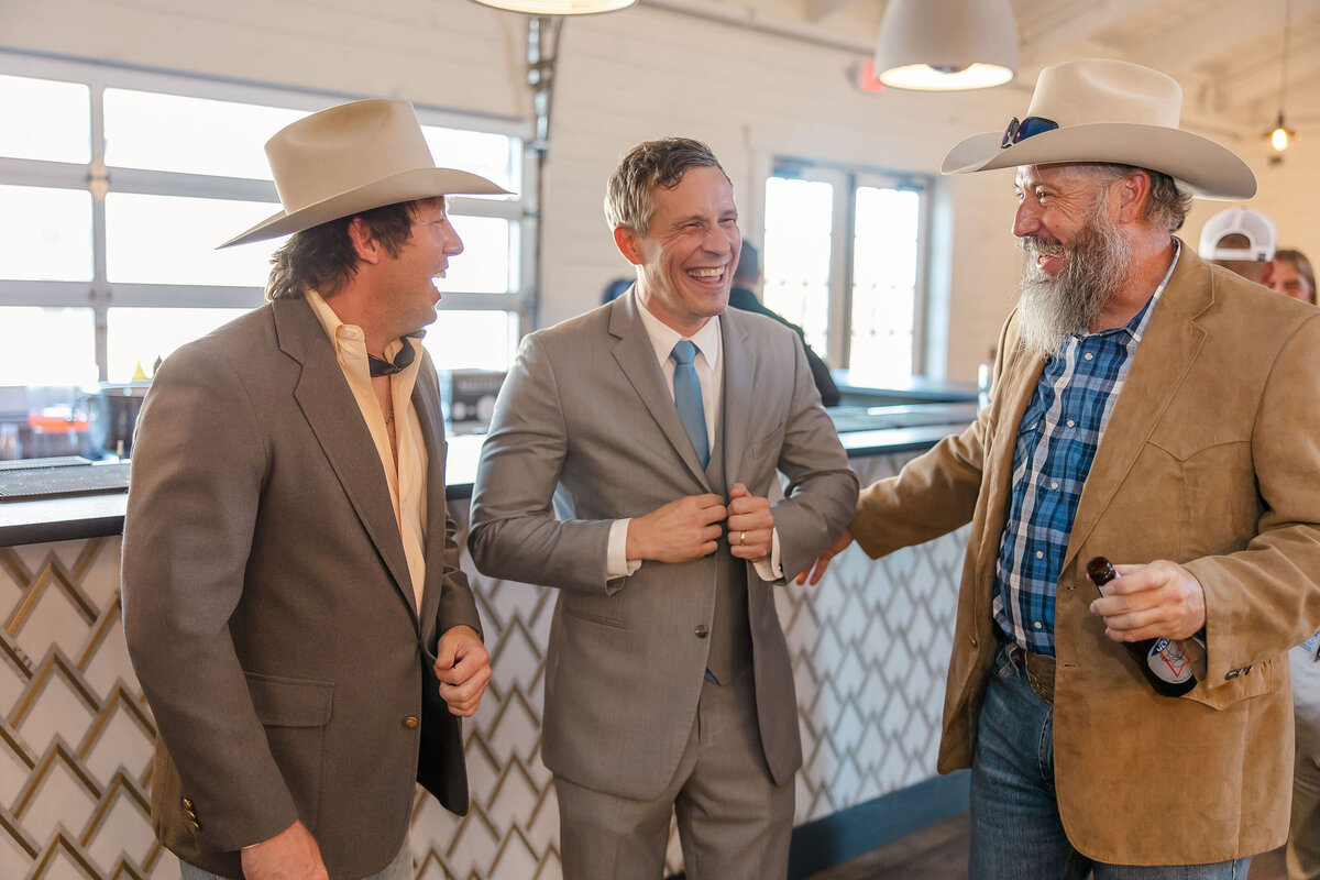 wedding guests in cowboy hats smile candidly at Texas wedding