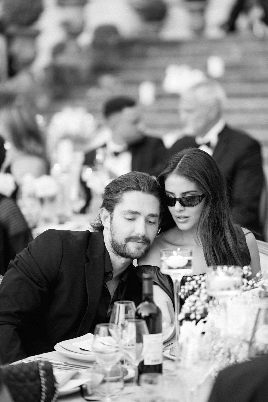 two guests leaning in toward each other during dinner