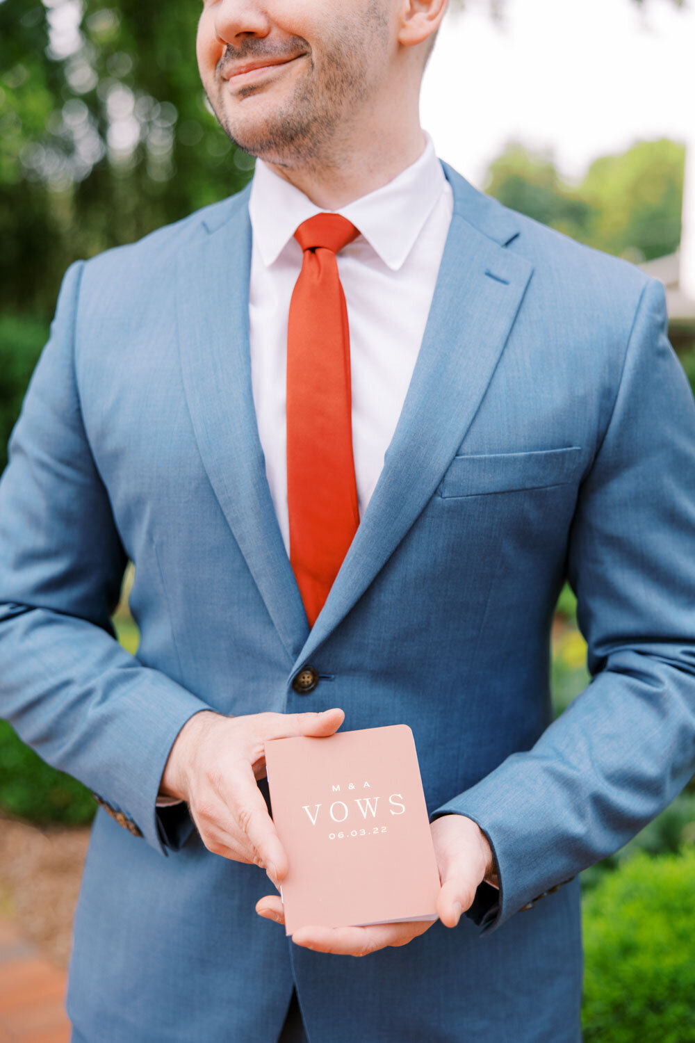Groom in a blue suite holding his wedding vows