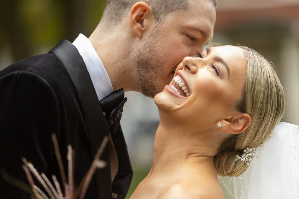 A man kissing a woman on the cheek while she laughs