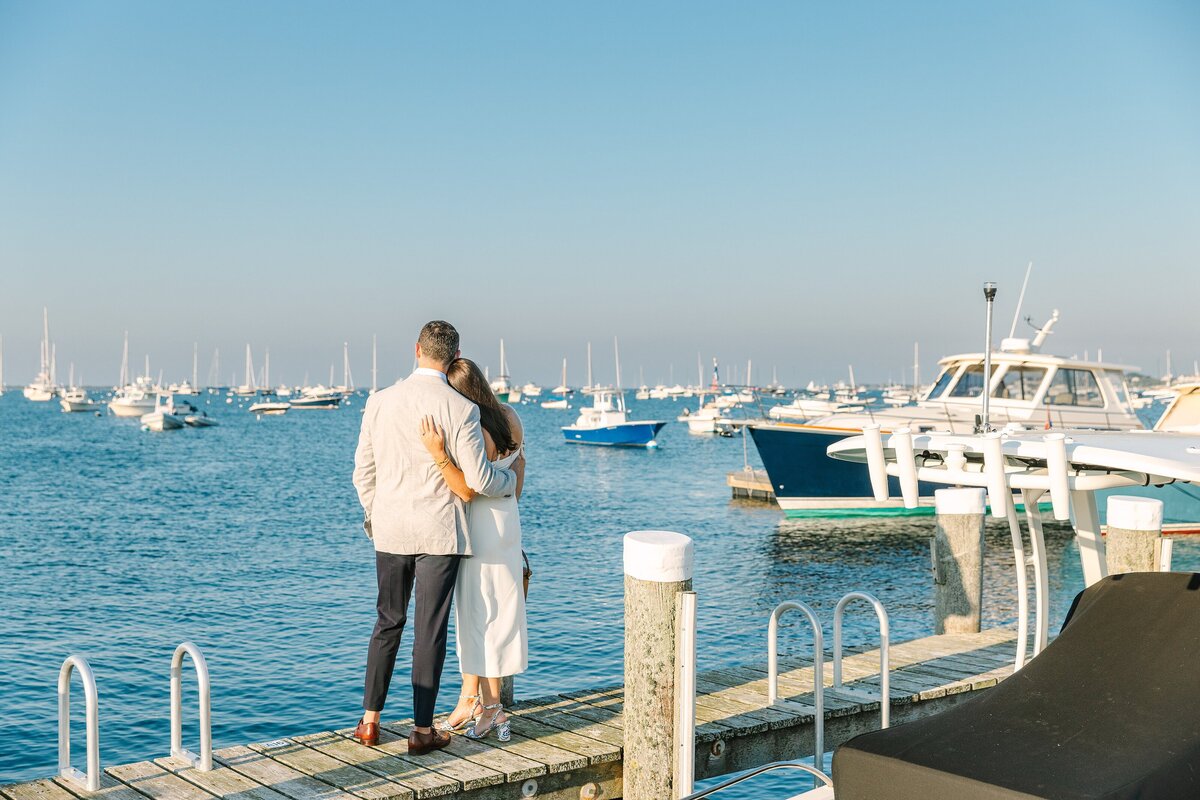 couple hugs and looks out toward the water