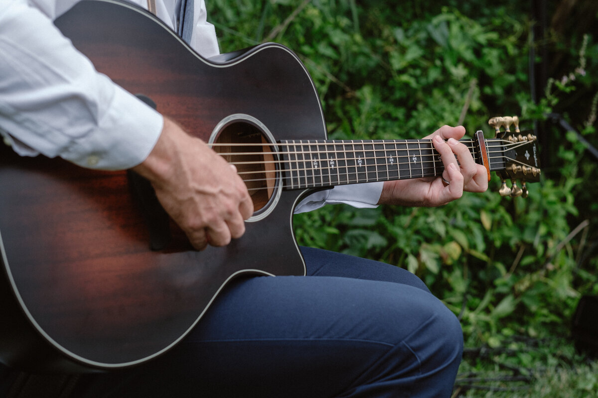 man playing guitar at wedding