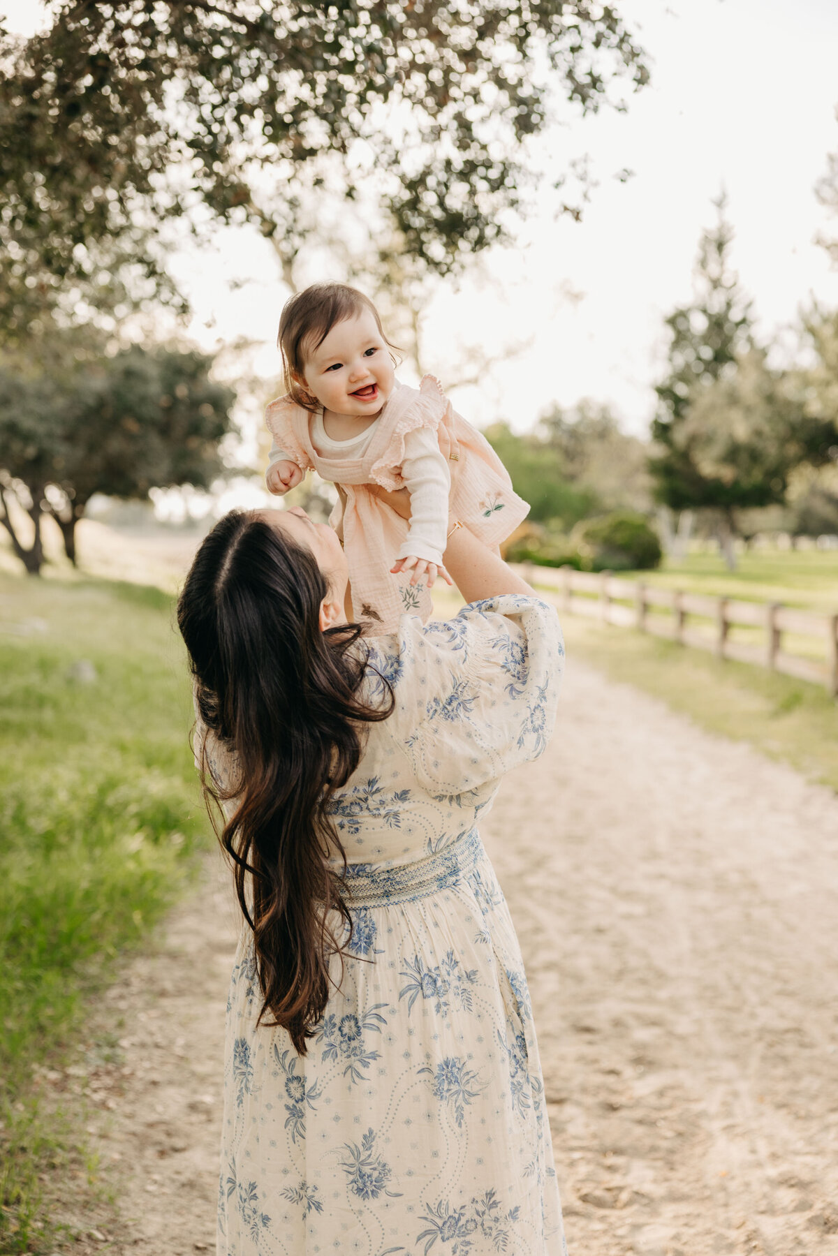 Mom holding baby girl up in the air