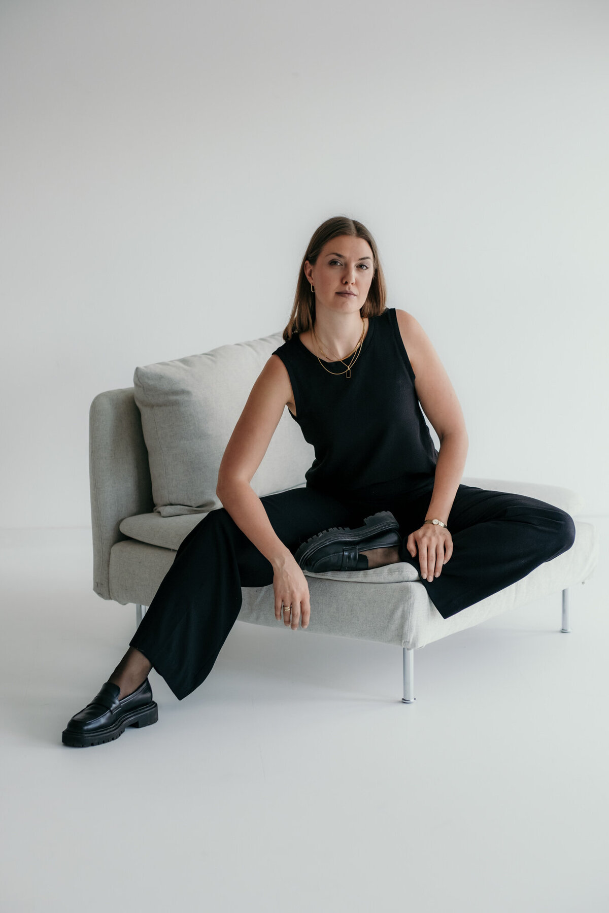 Woman is sitting comfortably on a sofa.