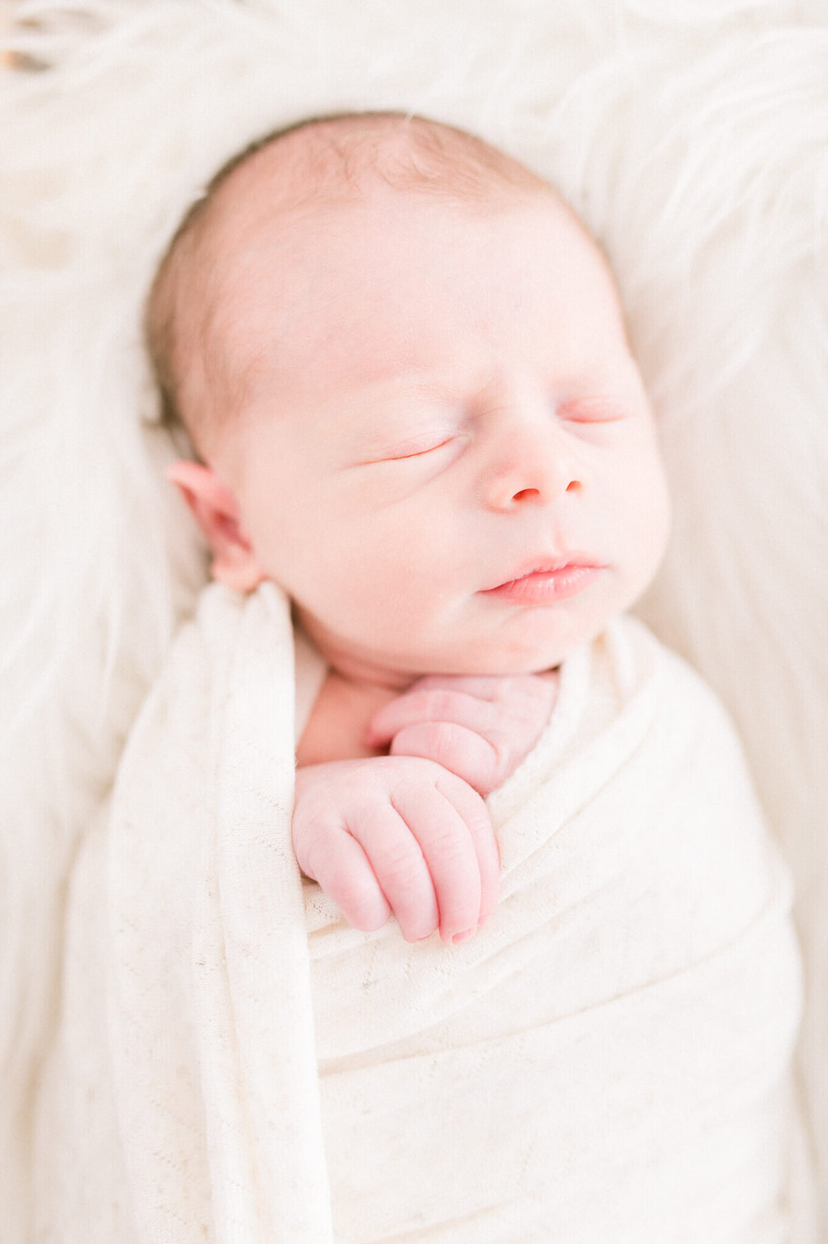 close up image of baby boy in a wrap. Captured by Niagara newborn photographer