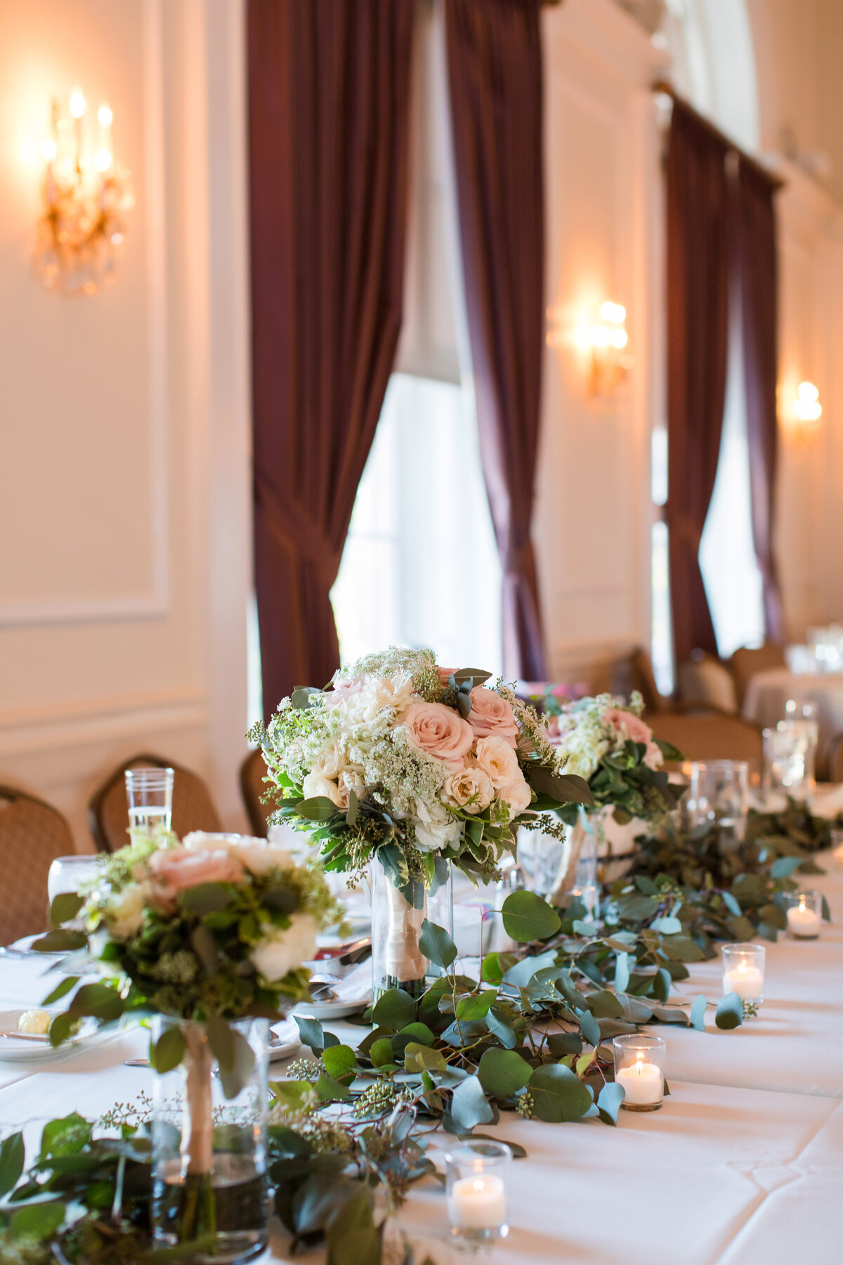 wedding head table with floral bouquets at university club