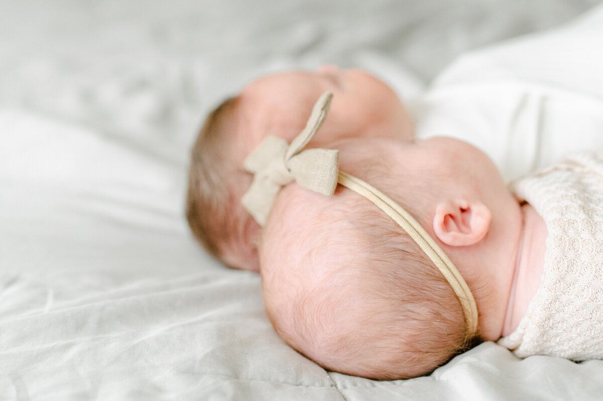 Twins laying next to eachother on bed newborn session