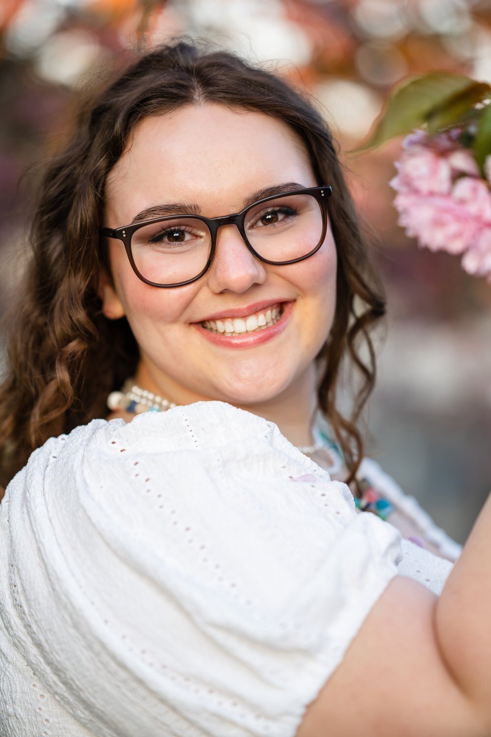 redmond high school senior girl in white dress with cherry blossoms