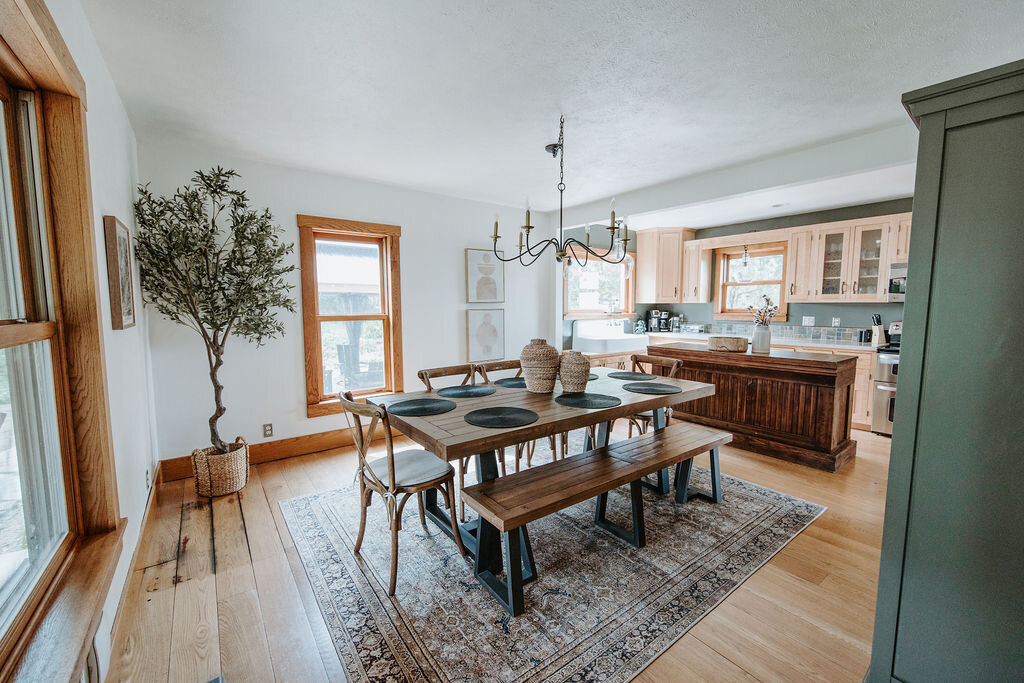 the dining room with faux olive tree and Loiloi rug  in the modern farmhouse overnight accommodations at the Willowbrook wedding venue