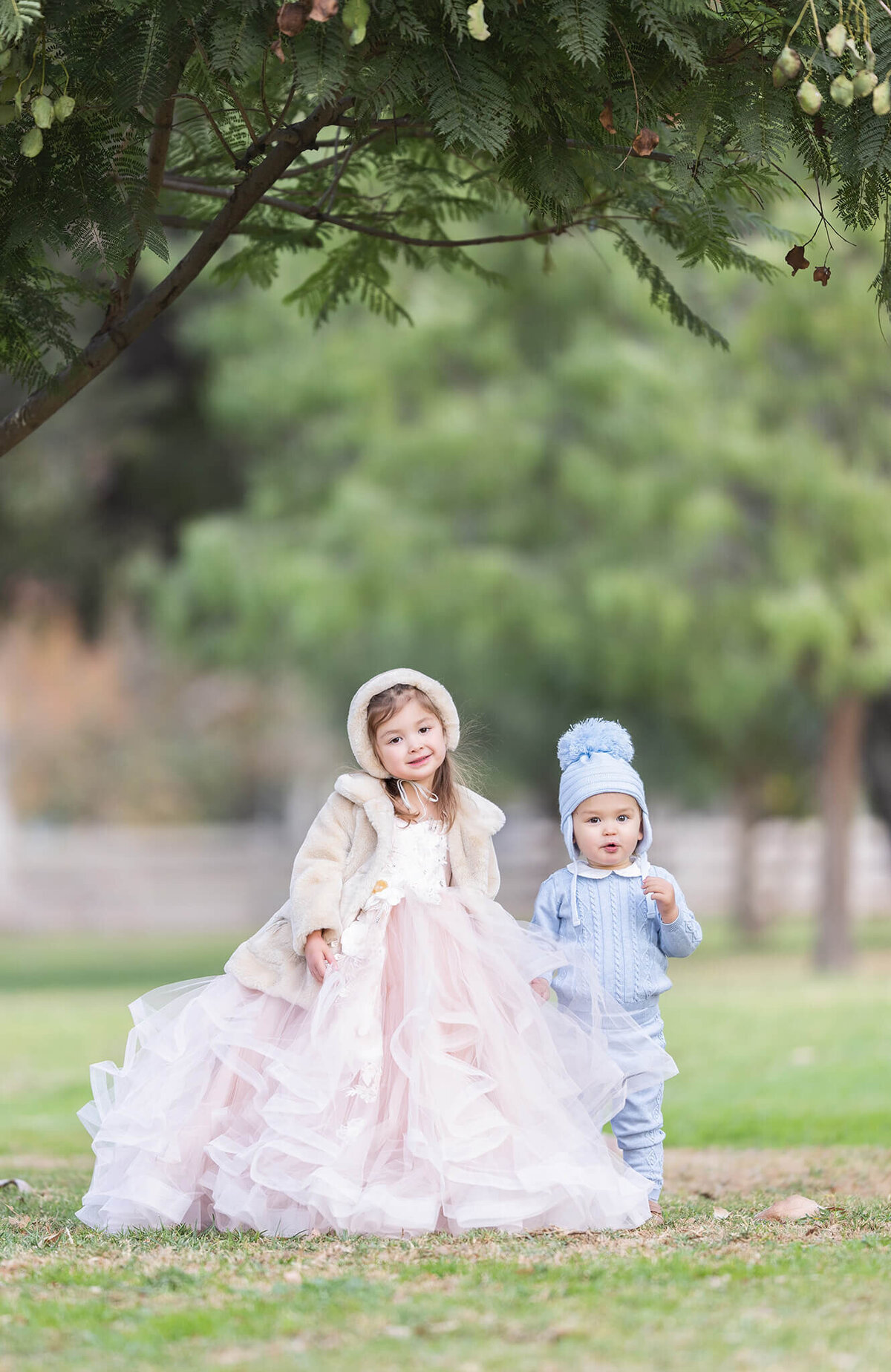 brother and sister holding hands in the park