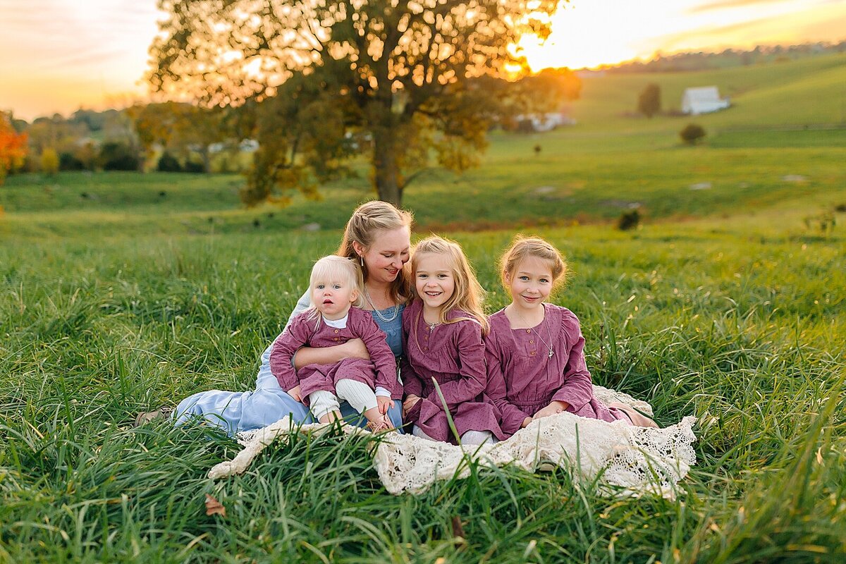 Mom and daughters in blue and purple in a field for family pictures near Staunton , VA