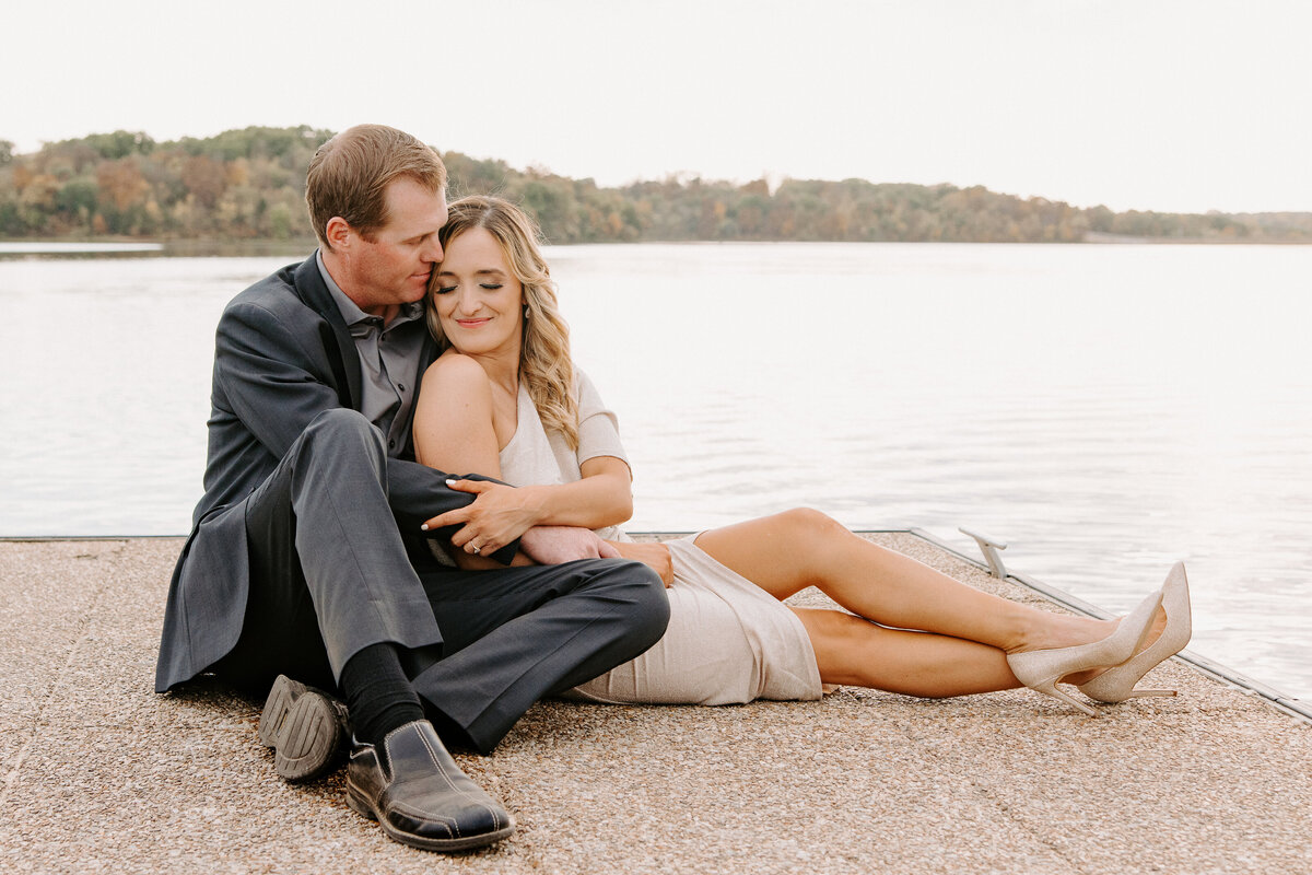 couple cuddling on boat dock wearing heels and formals