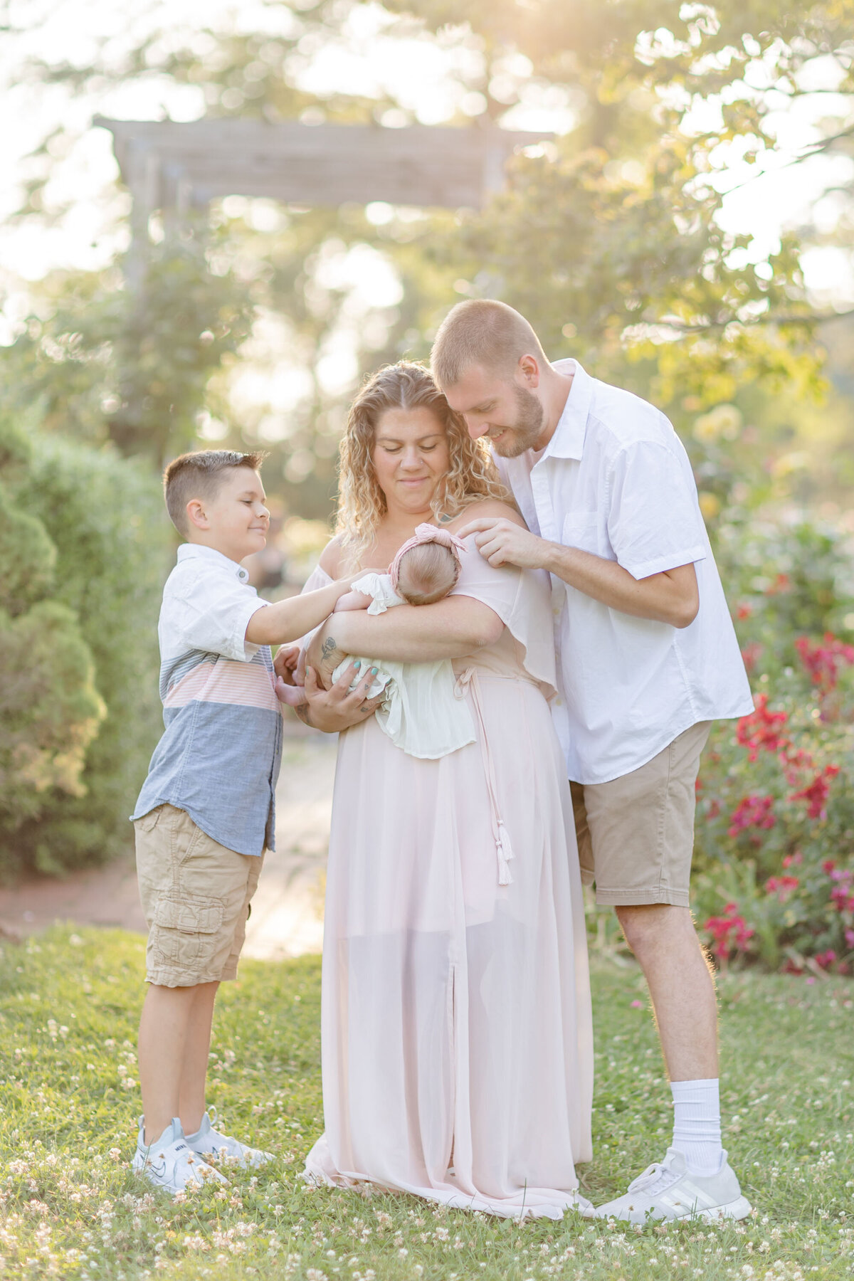 an outdoor family holds and admires their newest family member captured by Portrait Studio Stamford CT photographer