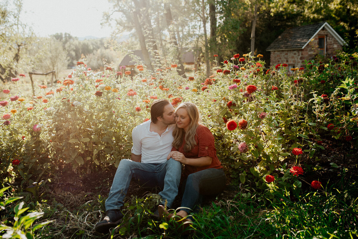 Couple sitting among a field of poppys on a farm in Bellvue Colorado