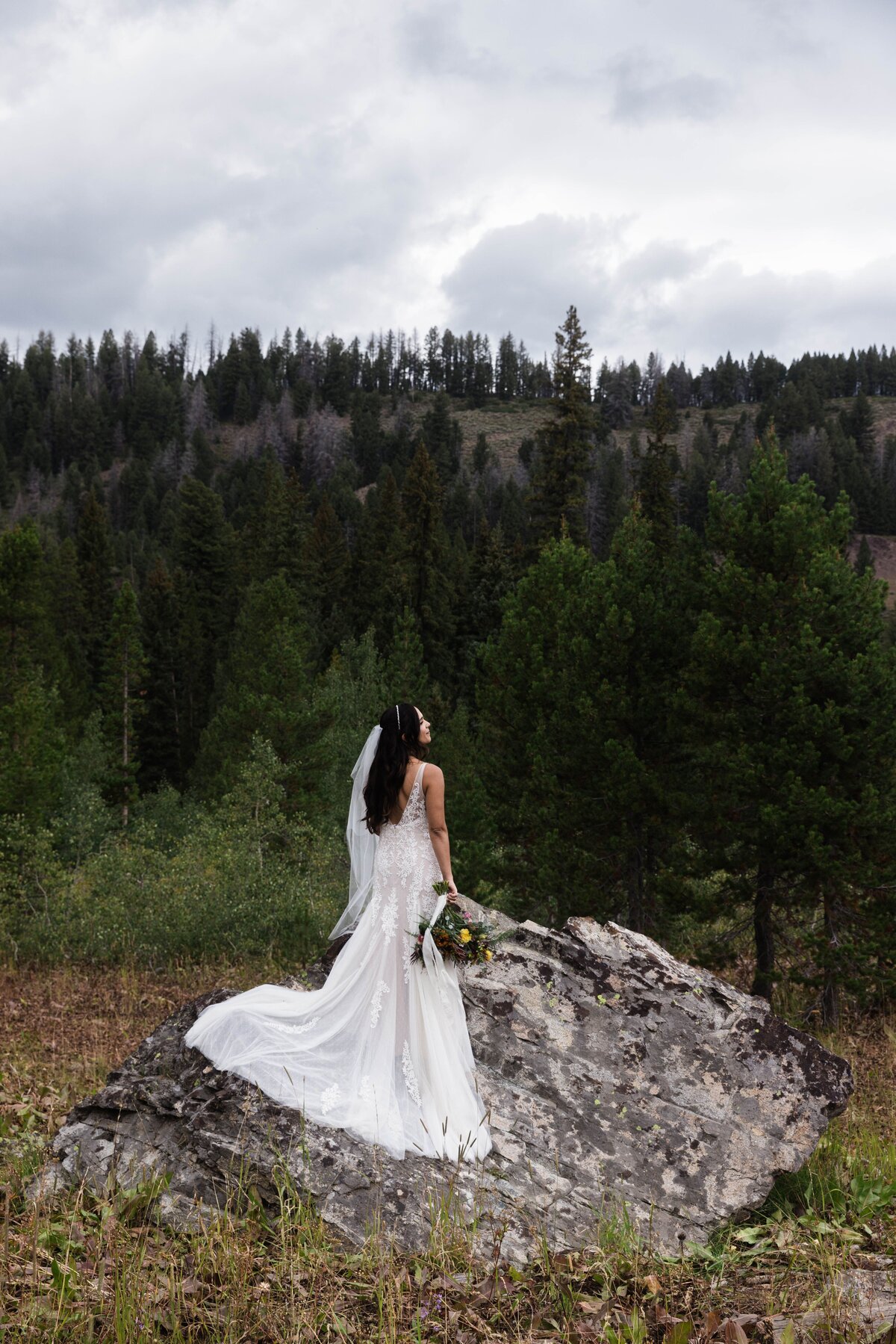 bride standing on a rock at Idaho outdoor wedding
