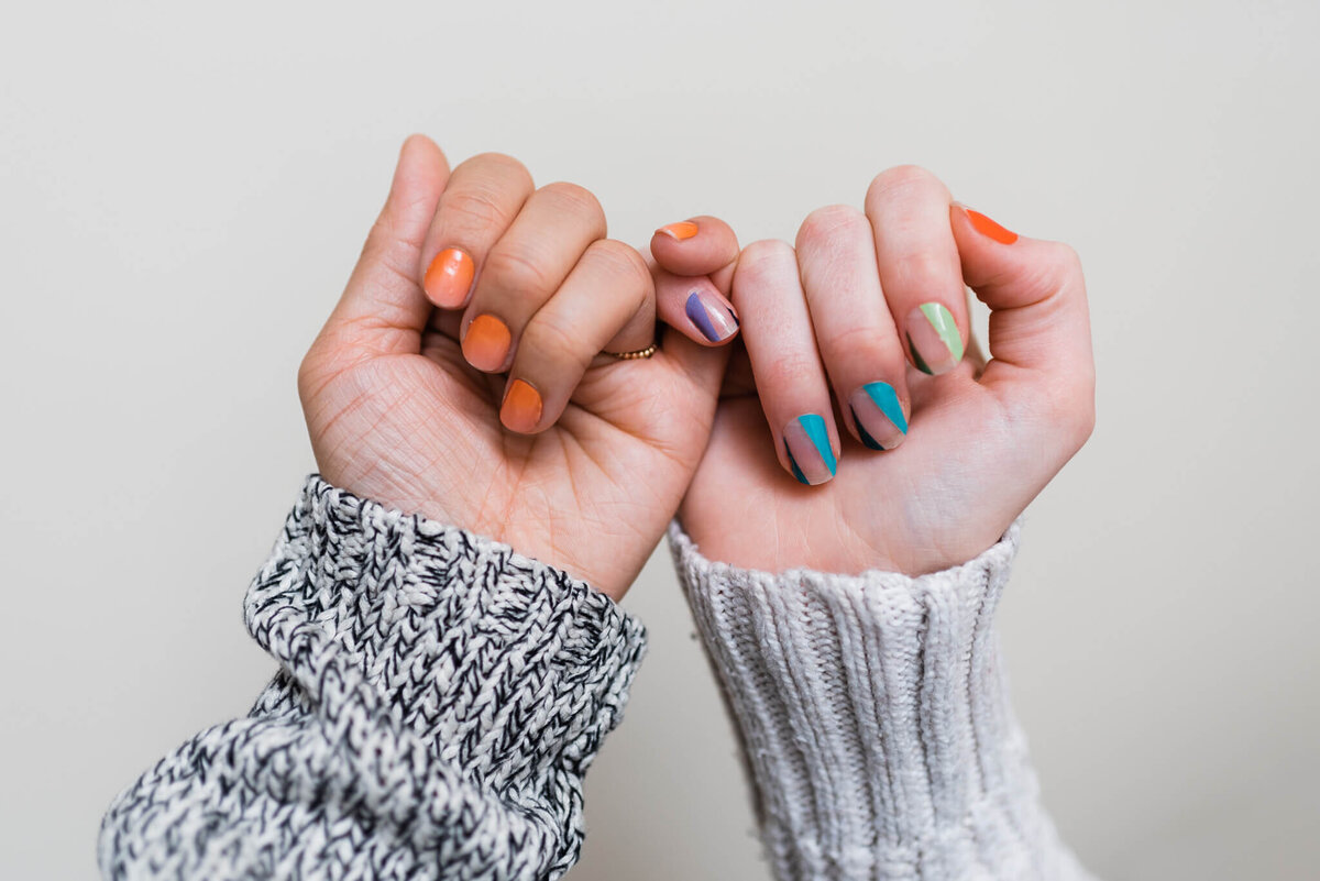 Asian and caucasian hand models wearing stick-on nails