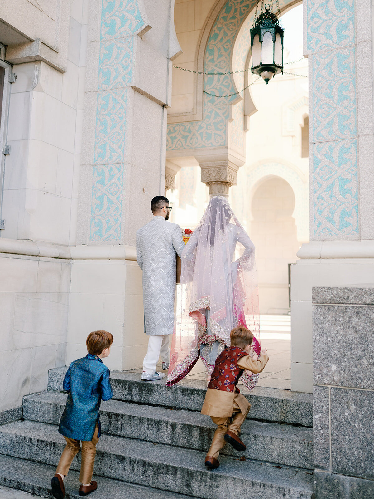 Couple walk as kids follow them to ceremony site
