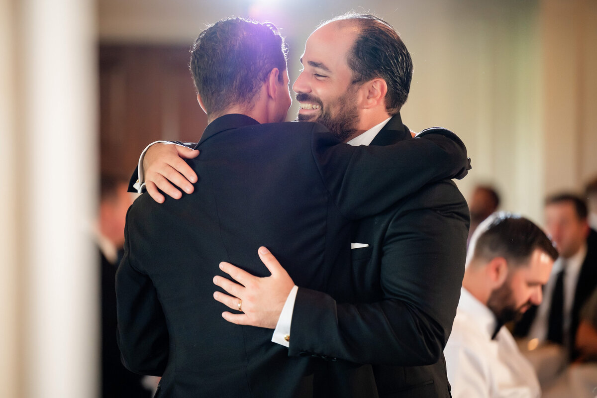 groom hugging best man after wedding toast