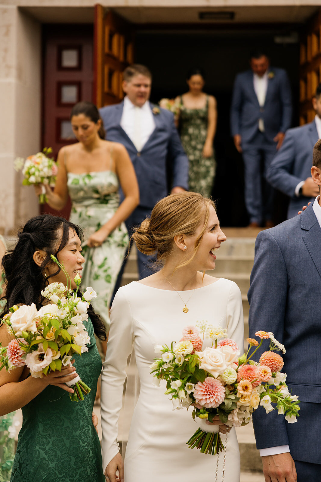 A bride leaves a Montreal church holding a bouquet of bright flowers.